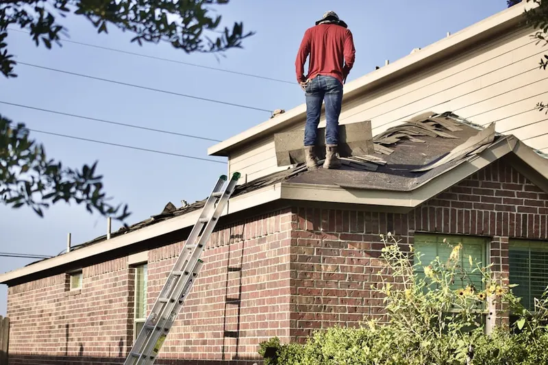 Professional roofer working on a residential roof in Saddle Rock Estates